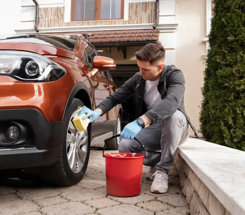 Lavage auto à domicile Saint-Geniès-de-Comolas : professionnel intervenant sur un véhicule